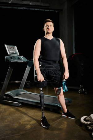 Téléchargez les photos : Un homme avec une prothèse de jambe debout sur un tapis roulant dans une pièce faiblement éclairée, activement engagé dans une routine d'entraînement. - en image libre de droit