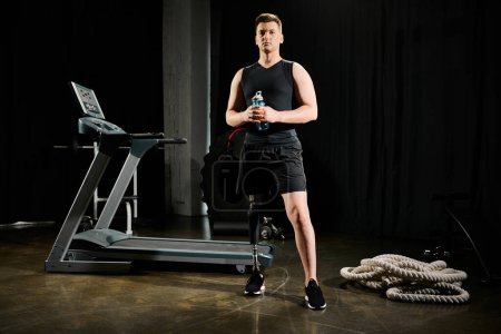 A man with a prosthetic leg stands in front of a treadmill, ready to work out in the gym.
