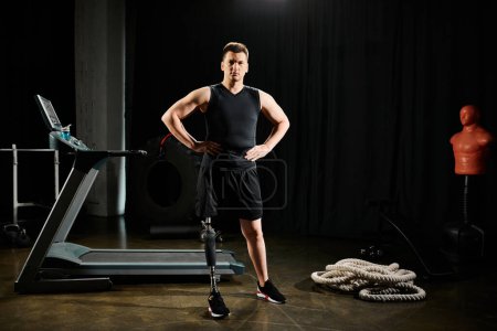 Un hombre con una pierna protésica se para con confianza frente a una cinta de correr, listo para desafiarse en el gimnasio.