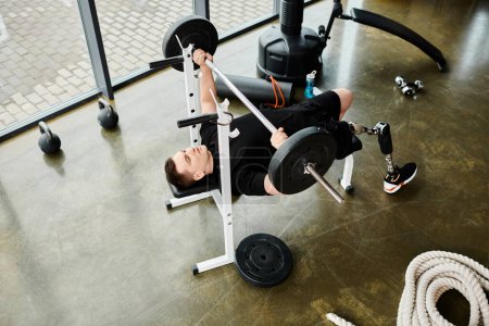 A disabled man with a prosthetic leg calmly laying on a bench in a gym, showing strength and resilience in his workout routine.