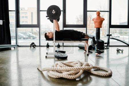 Photo for A disabled man with a prosthetic leg lies on a bench, facing a rope in front of him, in a determined workout session. - Royalty Free Image