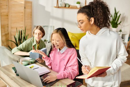 Eine Gruppe von interrassischen Teenagermädchen lernen gemeinsam mit Laptops am Tisch und fördern so Freundschaft und Bildung.