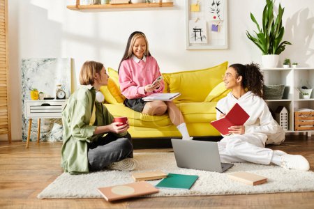 Diverse group of teenage girls gathered, chatting and studying while sitting on a vibrant yellow couch.