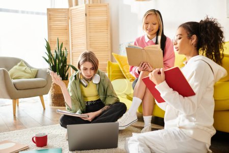 Eine Gruppe Teenager-Mädchen unterschiedlicher Herkunft sitzt um einen Laptop herum und lernt von zu Hause aus zusammen.