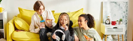 A diverse group of women lounging and chatting on a bright yellow couch in a cozy setting.