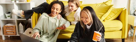 Exotische Teenager-Mädchen genießen Freundschaft auf einer gelben Couch, während sie zu Hause sitzen und chatten.