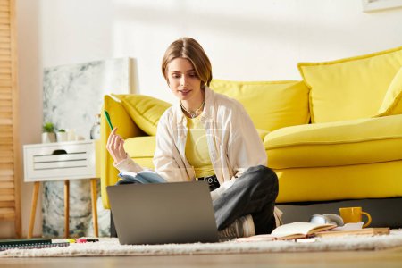 Téléchargez les photos : Une adolescente engagée dans l'apprentissage en ligne, assise sur le sol avec un ordinateur portable. - en image libre de droit