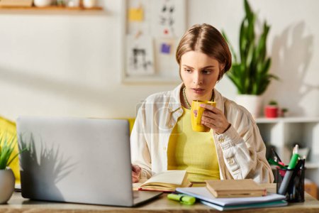 Una adolescente se sienta en un escritorio con una computadora portátil y una taza de café, centrada en su sesión de aprendizaje electrónico.