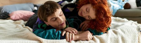 schöner Mann entspannt sich im Bett neben seiner rothaarigen verführerischen Freundin, während er zu Hause ist, Banner