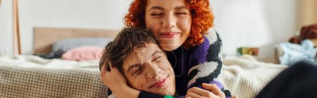 beautiful red haired woman hugging her handsome joyous boyfriend lovingly while at home, banner