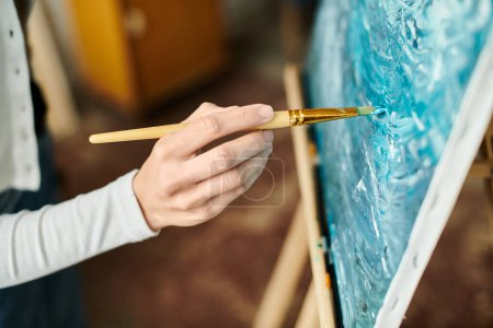 Une femme sophistiquée qui crée de l'art avec un pinceau devant une peinture.