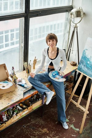 Eine kontemplative Frau auf einem Tisch neben einem Gemälde.