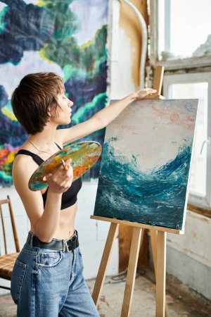 A woman with a paintbrush in hand, focused on painting a picture.