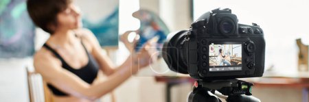 Téléchargez les photos : Femme montrant comment peindre à la caméra. - en image libre de droit