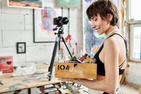 Mujer muestra caja de pintura delante de la cámara.