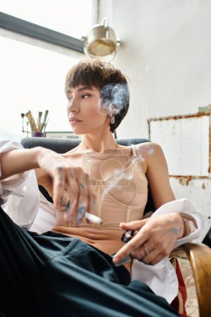 Sophisticated woman in chair, smoking a cigarette.