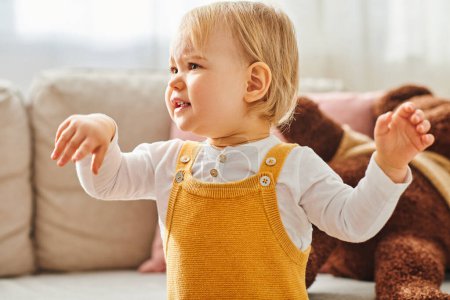 Kleinkind im gelben Kleid erlebt Freude in gemütlicher Umgebung.