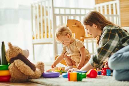Eine junge Mutter und ihre kleine Tochter beschäftigen sich fröhlich mit Spielzeug auf dem Fußboden und bauen eine starke, liebevolle Verbindung auf.