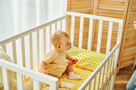 Photo for Toddler baby girl in a crib, sharing a precious moment of coziness at home. - Royalty Free Image