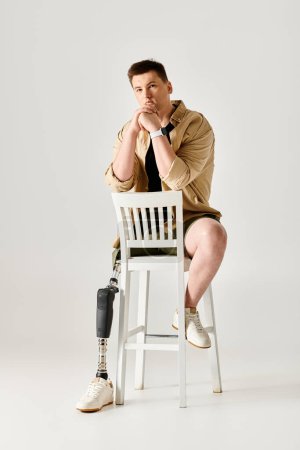 Ein gutaussehender Mann mit Beinprothese präsentiert dynamische Posen auf einem weißen Stuhl.