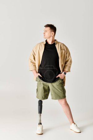 Un hombre guapo con una pierna protésica posa en una postura activa y elegante.