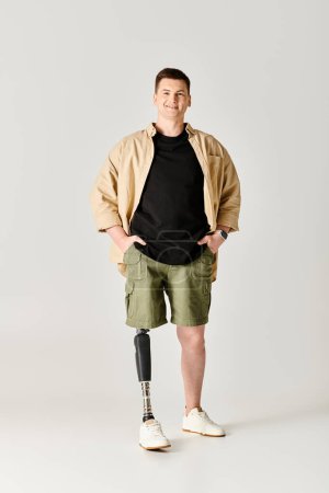 Handsome man with prosthetic leg standing confidently with hands on hips.