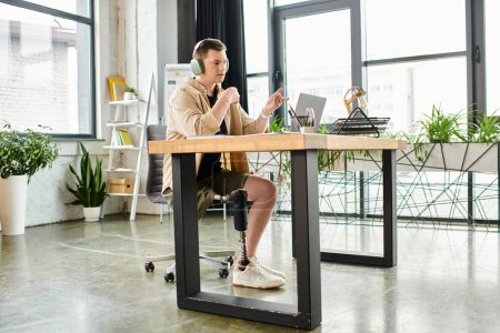Handsome businessman with prosthetic leg sitting at desk, using laptop.