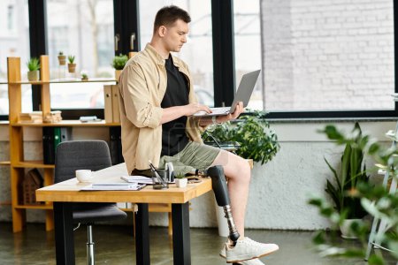 Bel homme d'affaires avec une jambe prothétique travaillant à un bureau avec un ordinateur portable.