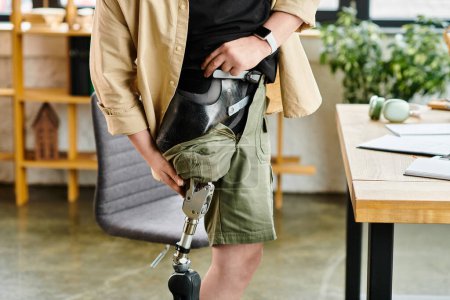 Ein gutaussehender Geschäftsmann mit Beinprothese posiert im Büro.