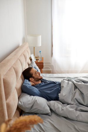 Foto de Un hombre descansa pacíficamente en la cama en casa. - Imagen libre de derechos