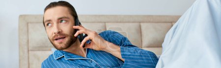 Un homme en pyjama bavardant sur un téléphone portable.