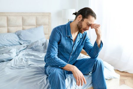 Un hombre guapo en pijama pacíficamente se sienta en una cama.