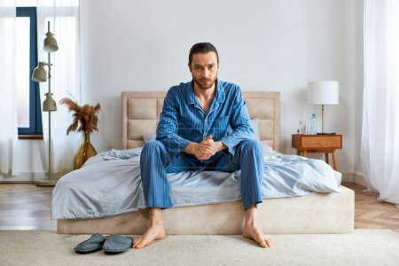 Foto de Hombre guapo en pijama encima de una cama. - Imagen libre de derechos