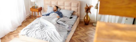 Foto de Un hombre pacíficamente acostado en su cama en un acogedor dormitorio. - Imagen libre de derechos