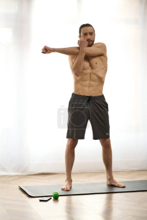 A man standing gracefully on a yoga mat, finding balance and peace at home.