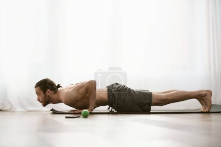 Photo for A man gracefully stretches at home. - Royalty Free Image