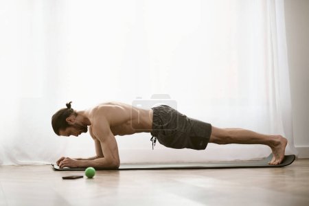 Handsome man practicing push ups on yoga mat in morning routine.