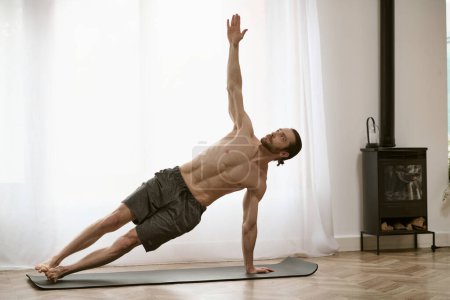 Foto de Un hombre guapo en su rutina matutina, practicando yoga en una esterilla. - Imagen libre de derechos