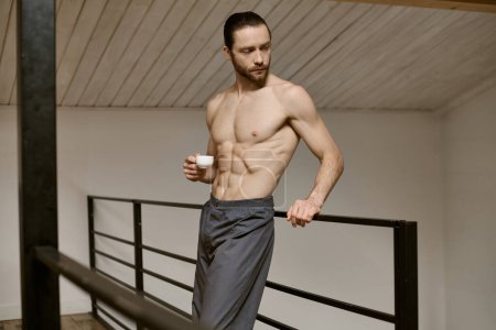 Shirtless man enjoying a cup of coffee at home.