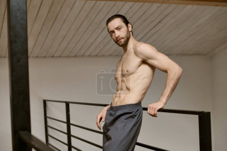 Shirtless man confidently stands on stairs.
