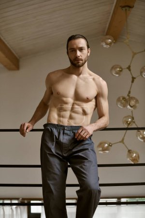 A shirtless man stands in a room, performing his morning routine.