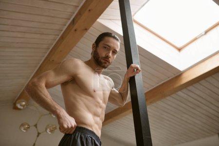 Shirtless man confidently posing at home, showcasing his strength.