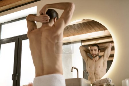 Un hombre con una toalla preparándose para el día, con un espejo.