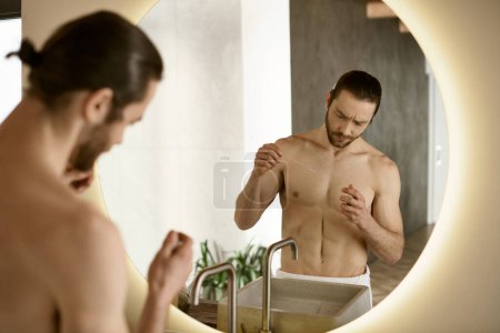 A man in front of a mirror brushing his teeth as part of his morning routine.