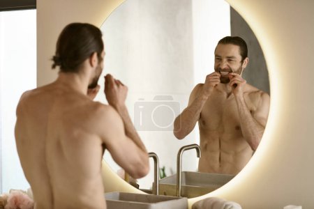 Ein Mann beim Zähneputzen vor dem Spiegel, Teil der morgendlichen Hautpflege-Routine.