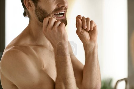 Shirtless man performing morning dental hygiene routine in front of a mirror.