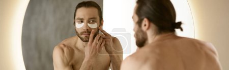 Foto de A man applying patches in front of a mirror during his morning routine. - Imagen libre de derechos