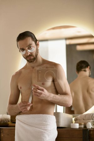 Ein Mann im Handtuch mit Nagelfeile, während er sich zu Hause vorbereitet.