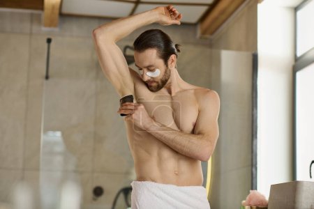 A man stylishly using deodorant with a towel around his waist during his morning routine.