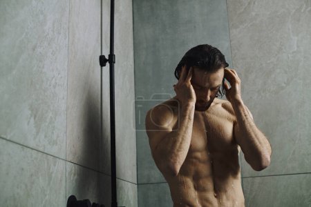 Shirtless man taking a shower.